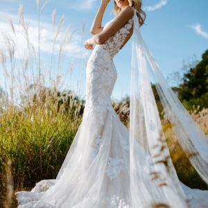 woman in white wedding dress standing on green grass field during daytime