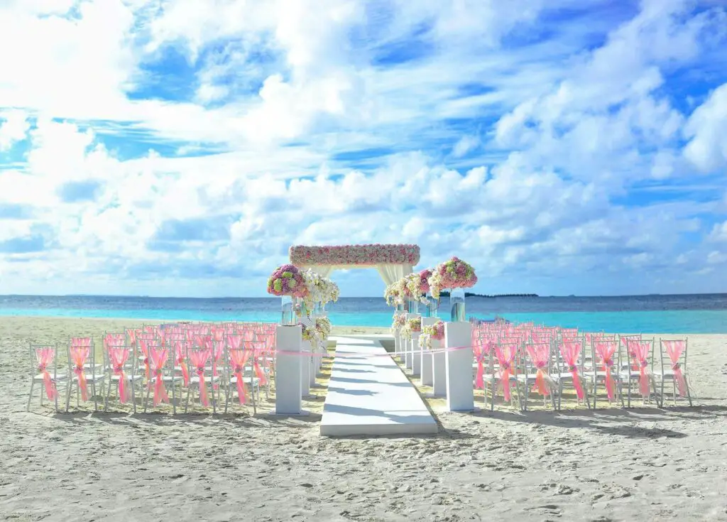 Elegant beach wedding setup in Maldives with floral decor and ocean view.