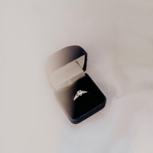 silver engagement ring on black box