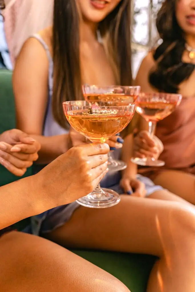 A group of women enjoying a celebration with champagne toasts indoors.