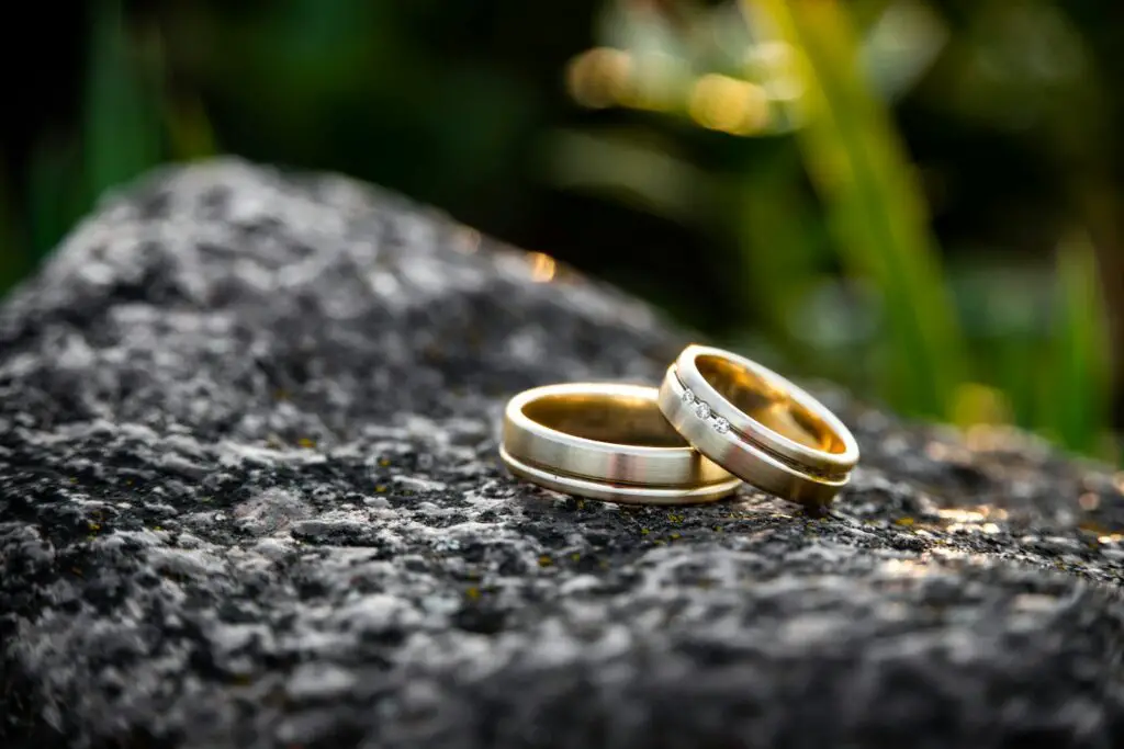 What Does A Wedding Ring Symbolize? 1 selective focus photography of two gold-colored rings on black stone during daytime